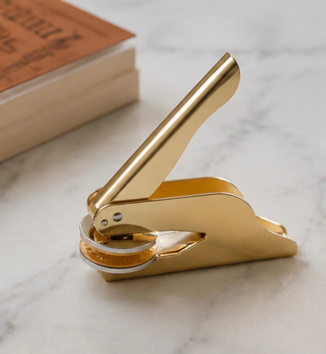 Gold book embosser on marble surface